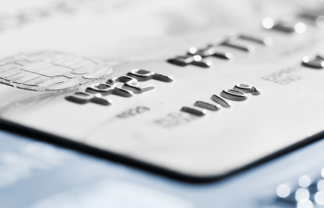 Carte de crédit grise posée sur une surface bleue 